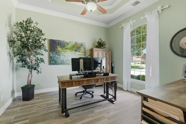 Home office with desk and tall window at 1000 Monticello Drive in Prosper