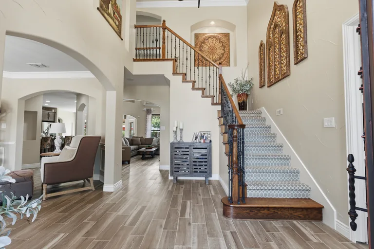 Entry hall, staircase and view toward the living room at 1000 Monticello Drive in Prosper