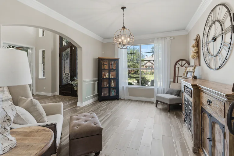 Sitting room with an arched opening and front door at 1000 Monticello Drive in Prosper