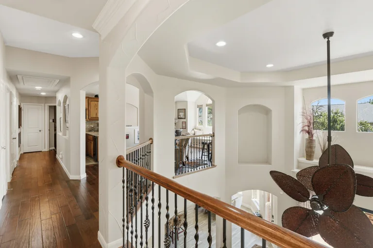 Upstairs landing and railing overlooking the living room at 1000 Monticello Drive in Prosper