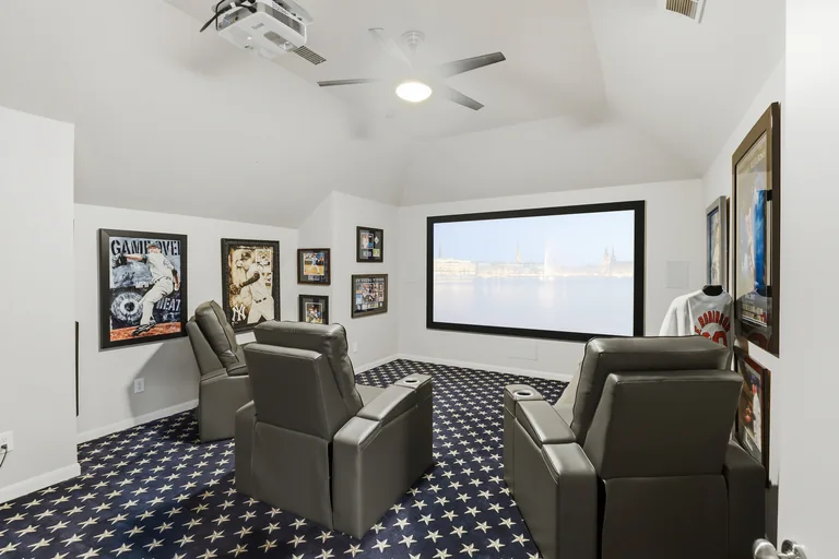 Media room with projection screen and reclining chairs at 1000 Monticello Drive in Prosper
