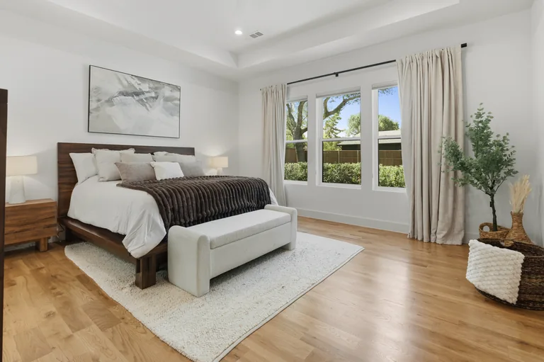 Bedroom with large windows and an upholstered bed at 3860 Walnut Hill Lane in Dallas