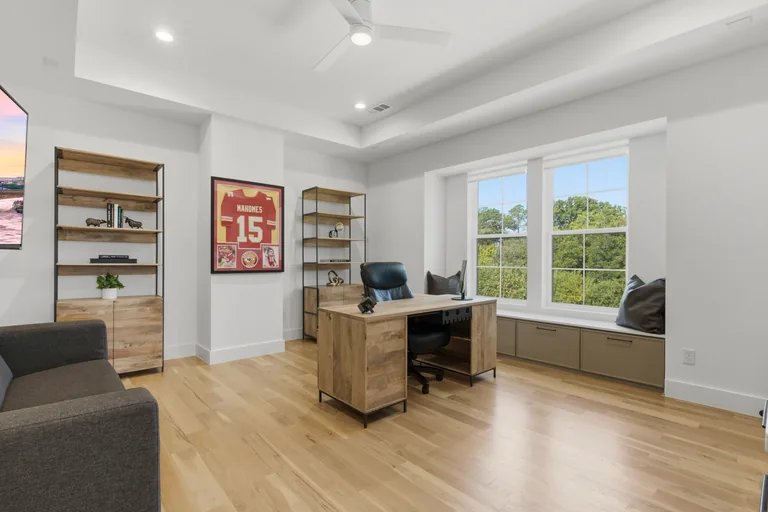 Home office with wood desk and large windows at 3860 Walnut Hill Lane in Dallas