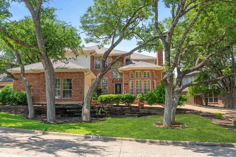 Two-story front exterior and landscaped lawn beneath mature trees — FLM media library example