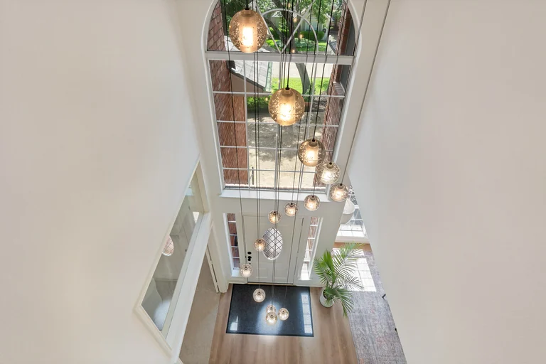 Tall entry hall and staircase with pendant lighting — FLM media library example