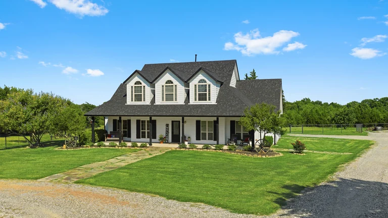 Exterior of a home with a broad lawn and open land beyond — FLM media library example