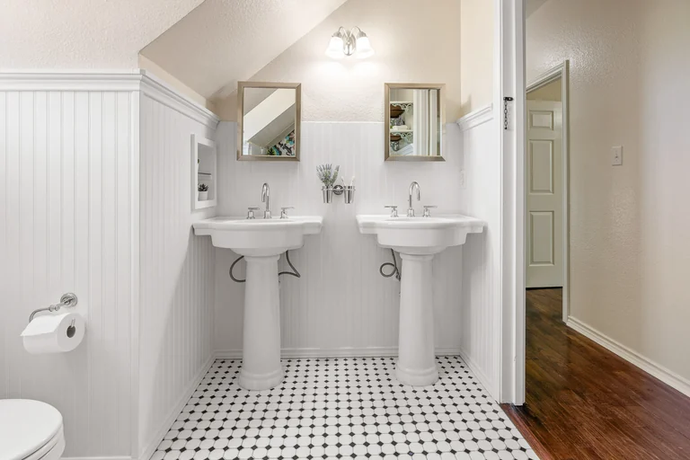 Bathroom with pedestal sinks, mirrors and tiled floor — FLM media library example