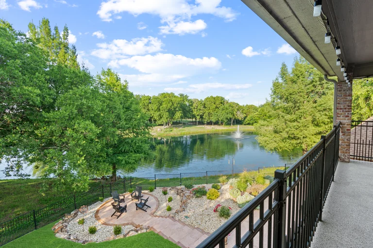 Covered terrace overlooking trees, a lawn and water — FLM media library example